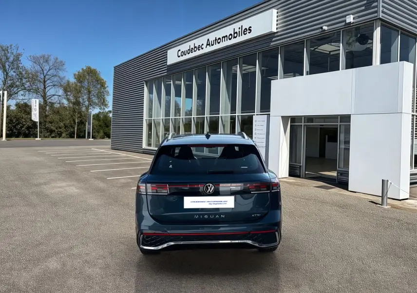 Vue arrière d'un Volkswagen Tiguan 2025 bleu garé devant un showroom Coudebec Automobiles.