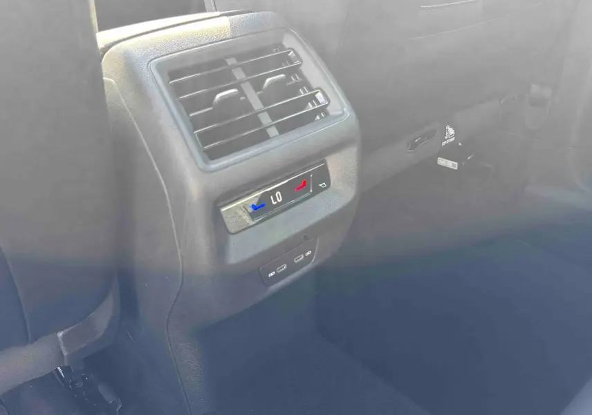 Détail de la console centrale arrière avec réglage climatisation et prises USB du Volkswagen Tiguan bleu 2025.