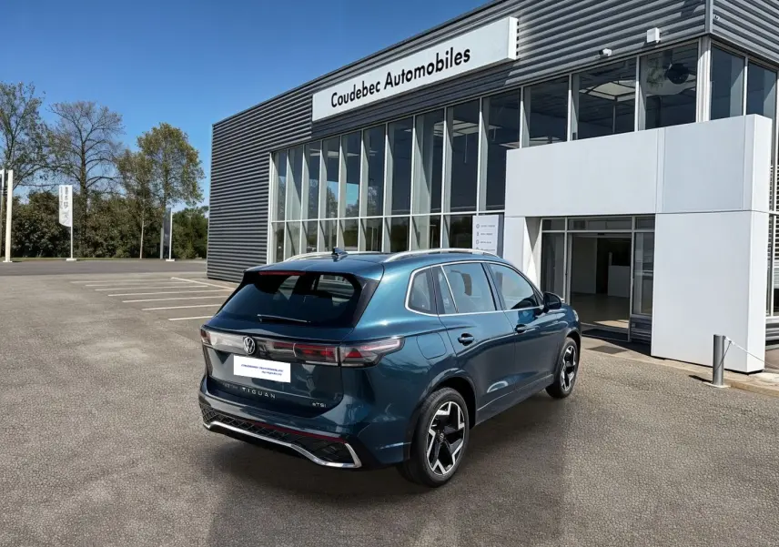 Volkswagen Tiguan 2025 bleu en vue 3/4 arrière droit, avec jantes alliage 19 pouces et feux arrière LED 3D.