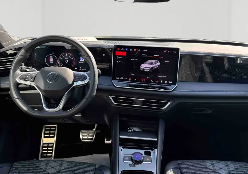 Vue intérieure frontale du Volkswagen Tiguan 2025 avec tableau de bord numérique et écran tactile central lumineux.