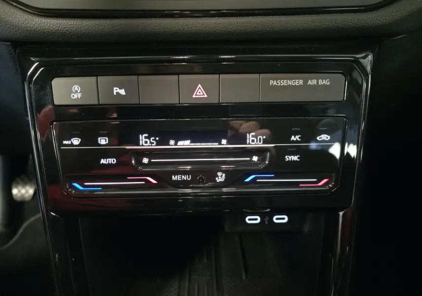 Vue rapprochée de la console centrale du Volkswagen T-Cross gris 2025, affichant la climatisation bi-zone et ports USB-C.