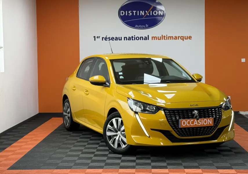 Peugeot 208 jaune clair vue 3/4 avant droit, avec calandre noire et jantes 16 pouces en tôle avec enjoliveurs.