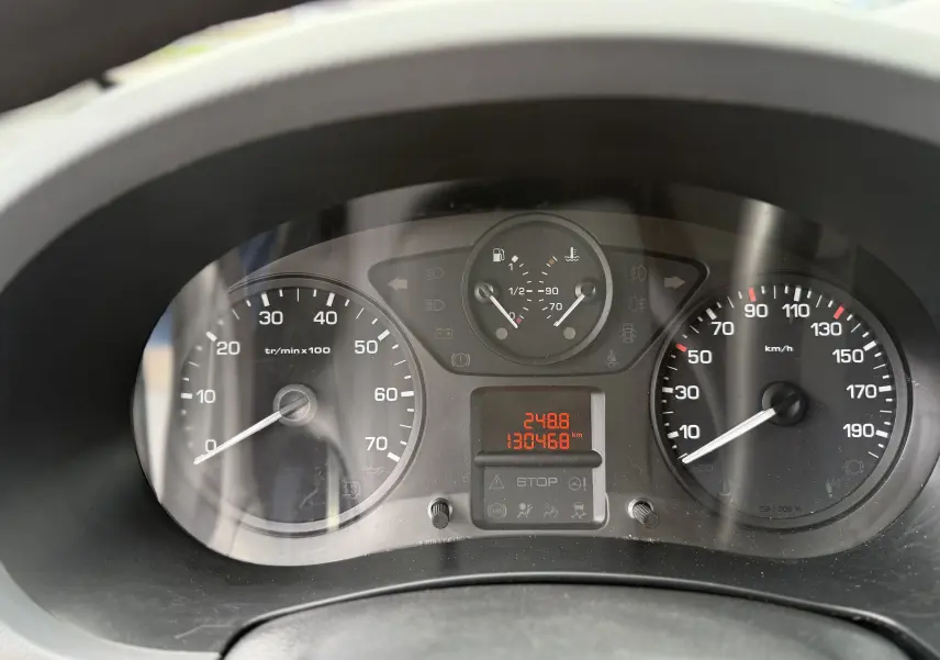 Vue rapprochée du tableau de bord du Peugeot Partner blanc 2017, affichant compte-tours, vitesse et jauges.