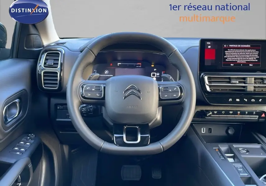Vue intérieure centrée sur le volant et le tableau de bord numérique du Citroën C5 Aircross 2025 finition cuir noir.