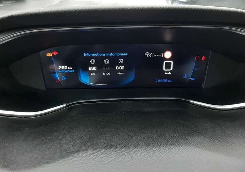 Vue rapprochée du tableau de bord numérique d'une Peugeot 308 SW gris Artense, affichant l'autonomie et la vitesse à 0 km/h.