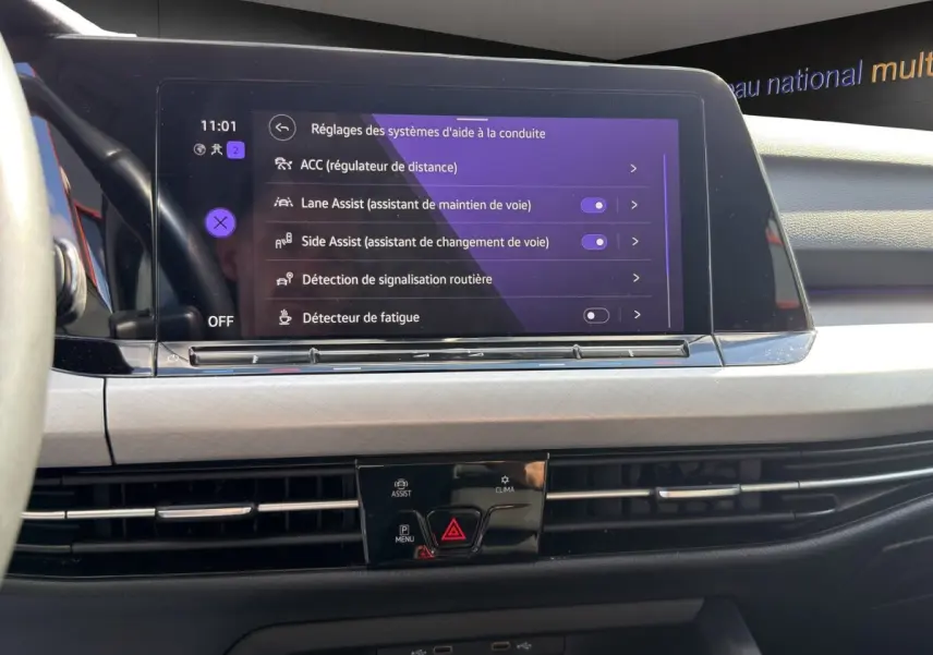 Écran tactile central de la Volkswagen Golf 2022 affichant les réglages d'aide à la conduite, vue de face intérieure.