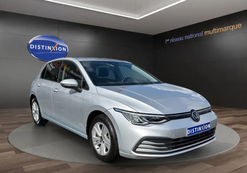 Volkswagen Golf gris clair vue 3/4 avant droit, avec phares LED et jantes alliage cinq branches.
