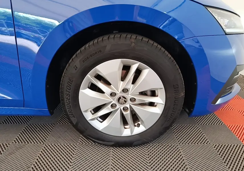 Gros plan sur la roue avant droite d’une Skoda Octavia bleue 2024 avec jante argentée et pneu Bridgestone.