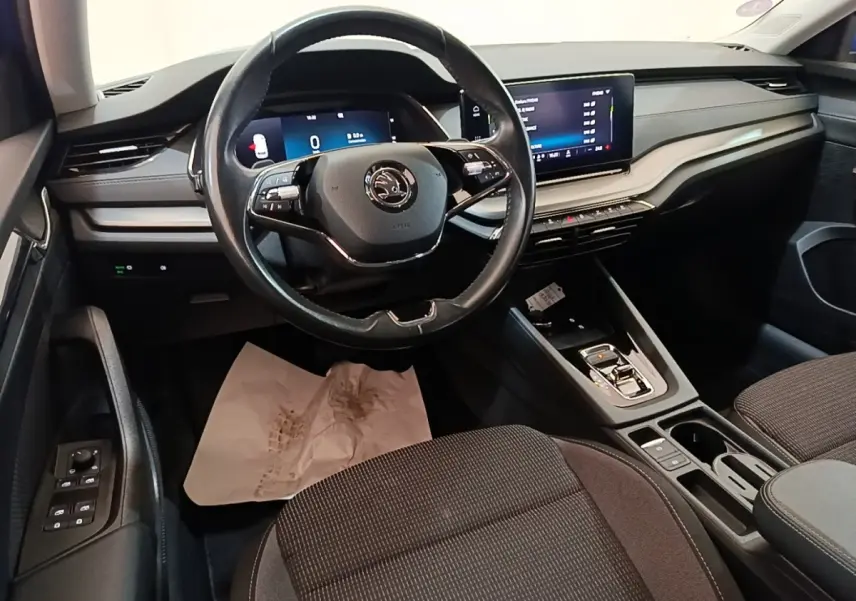 Intérieur de la Skoda Octavia 2024 vue côté conducteur, volant cuir noir et tableau de bord avec écran tactile.