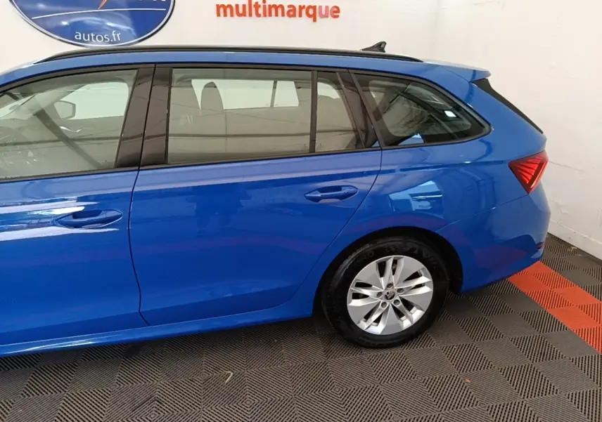 Vue latérale droite d'une Skoda Octavia break 2024 bleu vif avec jantes argentées et vitres teintées.