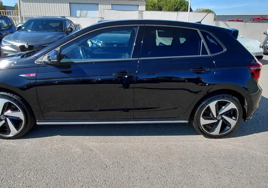 Volkswagen Polo GTI noire vue de profil côté gauche, avec jantes alliage 17 pouces et badge GTI rouge.