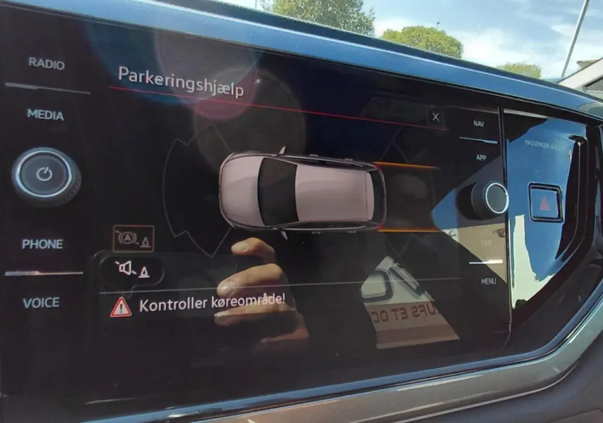 Écran tactile central de la Volkswagen Polo GTI 2024 noir montrant l'aide au stationnement et les commandes multimédia.