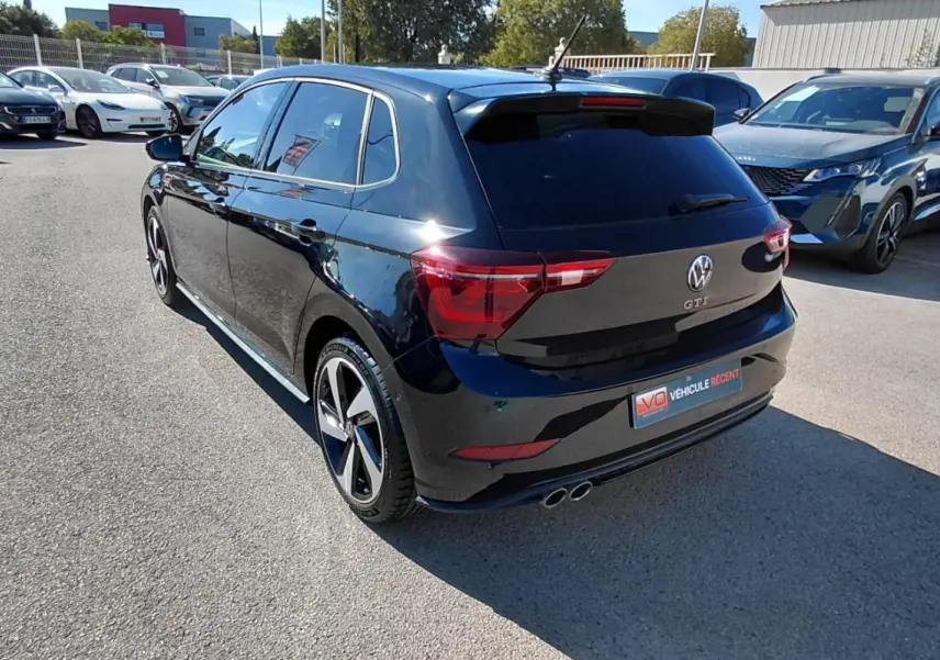 Volkswagen Polo GTI noir vue 3/4 arrière droit, jantes alliage 17 pouces et double sortie d’échappement chrome.