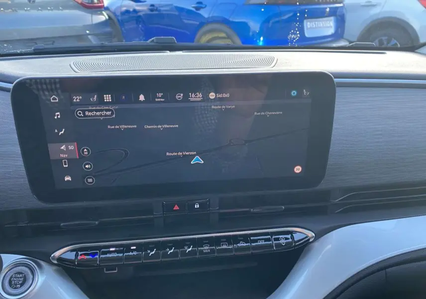 Tableau de bord de la Fiat 500 électrique noire 2022 avec écran tactile de navigation et commandes climatisation visibles.