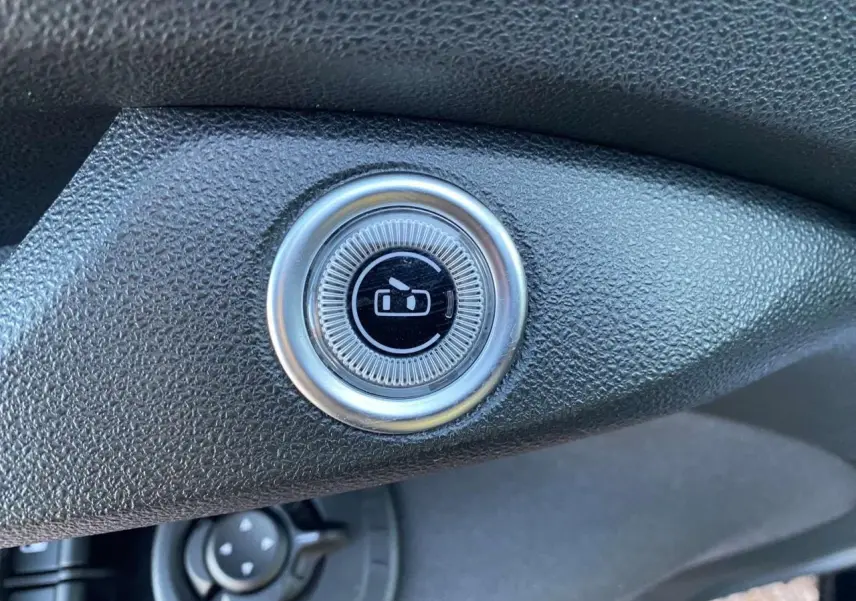 Bouton rond de commande des rétroviseurs sur tableau de bord noir de la Fiat 500 électrique 2022.