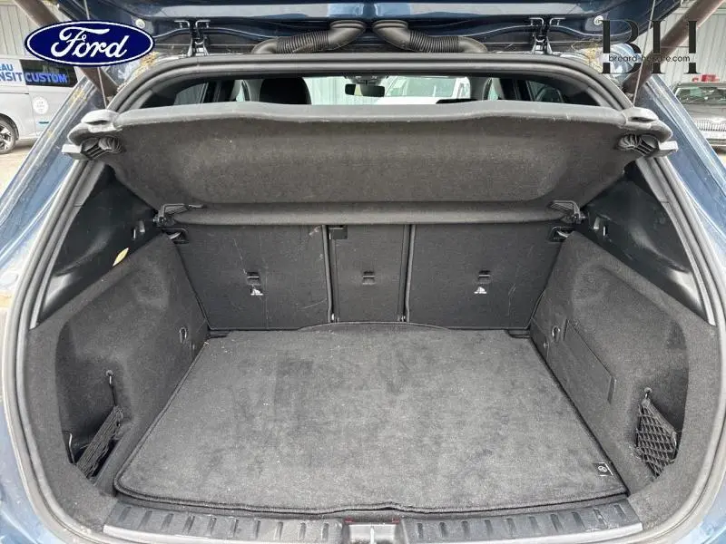 Coffre ouvert d'une Mercedes GLA 250 e bleu denim métallisé, montrant l'espace de chargement et la plage arrière.