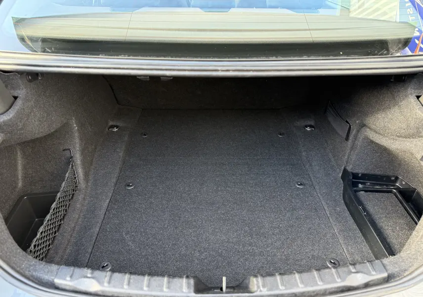 Coffre ouvert d'une BMW Série 3 320D gris 2013, montrant un espace de rangement propre et bien fini.