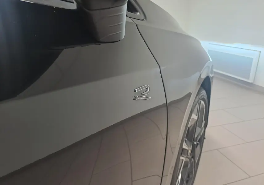 Détail du côté gauche d’une Volkswagen Golf 2.0 TDI R Line noir grenadille avec logo R et jante alliage 18 pouces.