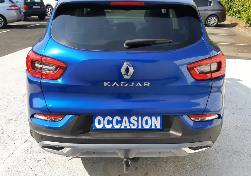 Vue arrière d'un Renault Kadjar bleu Iron 2020 avec logo et plaque "OCCASION" visible en extérieur.