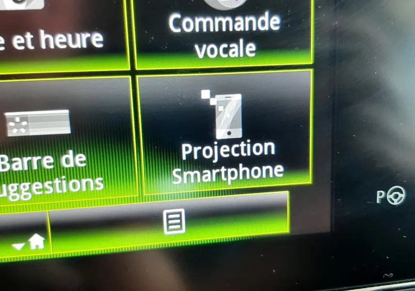 Détail de l'écran tactile central du Renault Kadjar 2020 montrant les options de commande vocale et projection smartphone.