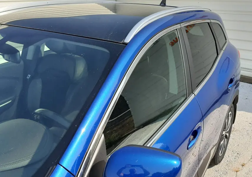 Vue 3/4 avant droit du Renault Kadjar 1.5 DCI 115 Intens EDC bleu iron, avec toit panoramique et rétroviseur assorti.