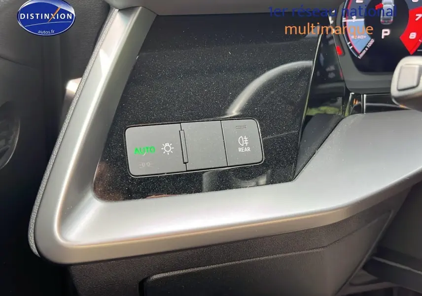 Détail du tableau de bord côté gauche de l'Audi A3 Sportback 2023 avec commandes d'éclairage automatiques activées.