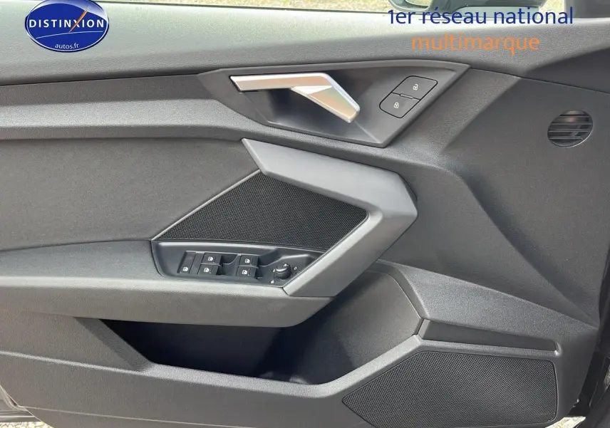 Détail de la porte avant gauche de l'Audi A3 Sportback 2023 avec commandes de vitres et poignée argentée.