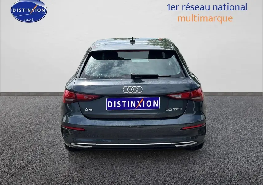 Vue arrière d'une Audi A3 Sportback gris Manhattan 2023 avec feux LED et logo distinctif sur hayon.