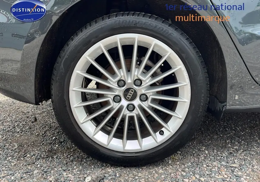 Gros plan sur la jante alu 17 pouces argentée avec logo Audi sur une Audi A3 Sportback gris Manhattan.