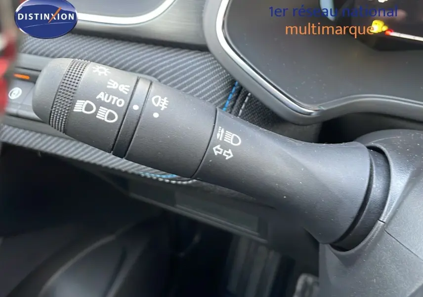 Gros plan sur la commande des feux et clignotants dans l'habitacle du Renault Captur E-Tech hybride noir étoile.