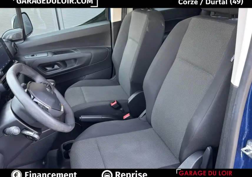 Vue intérieure côté conducteur du Peugeot Rifter bleu 2024, montrant les sièges avant en tissu gris et noir.