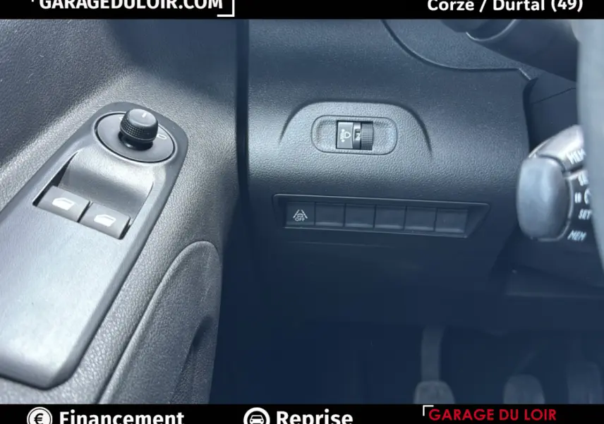 Détail des commandes côté gauche du tableau de bord d’un Peugeot Rifter bleu 2024, avec réglage des rétroviseurs et interrupteurs.