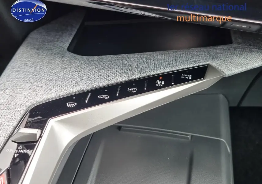 Vue rapprochée du panneau de commandes de climatisation et mode de conduite sur la console centrale grise du Peugeot 3008 blanc.