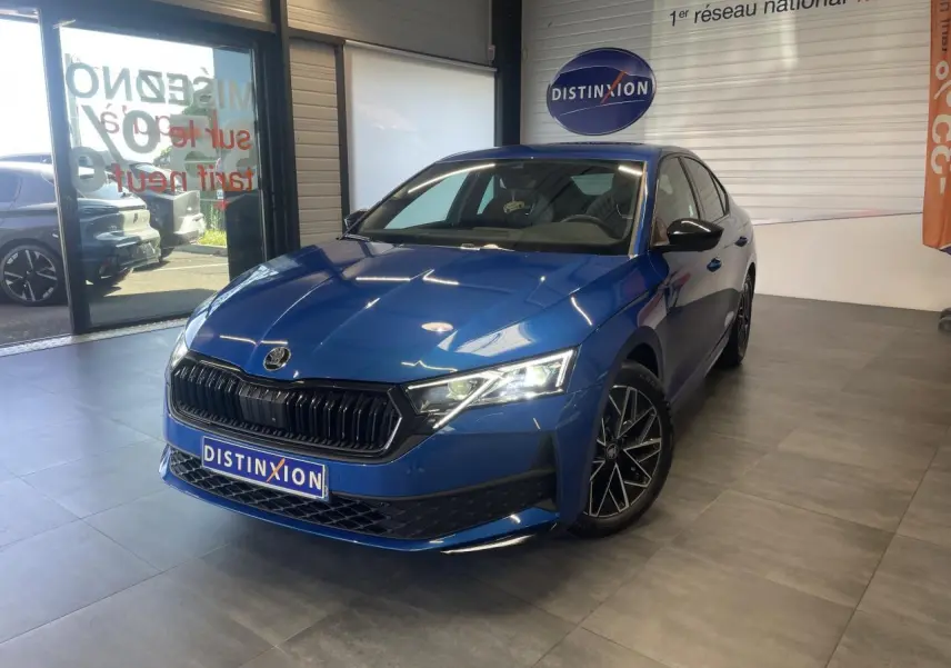 Skoda Octavia 2025 bleu foncé vue 3/4 avant en intérieur avec jantes alliage noires et calandre marquée Sportline.