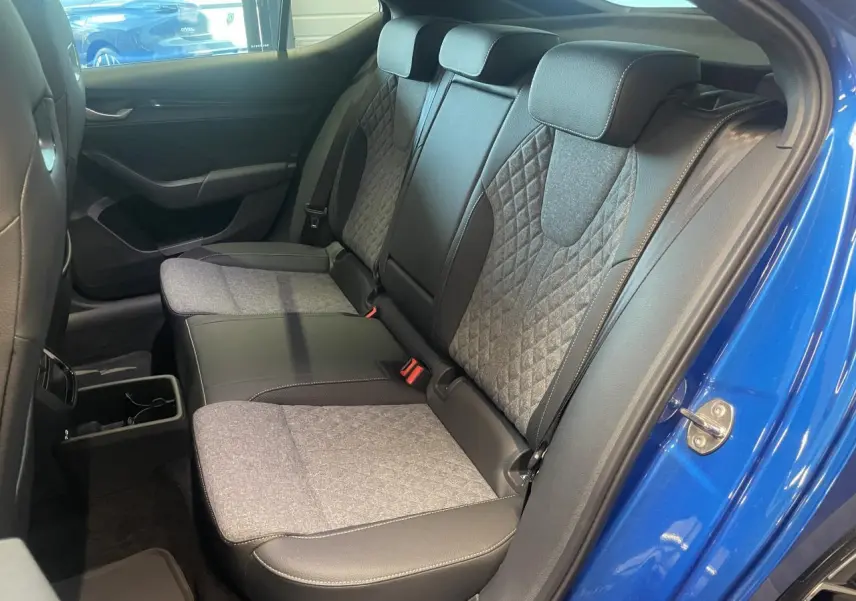Vue intérieure côté droit sur la banquette arrière bicolore gris et noir d'une Skoda Octavia Bleu foncé 2025 Sportline.
