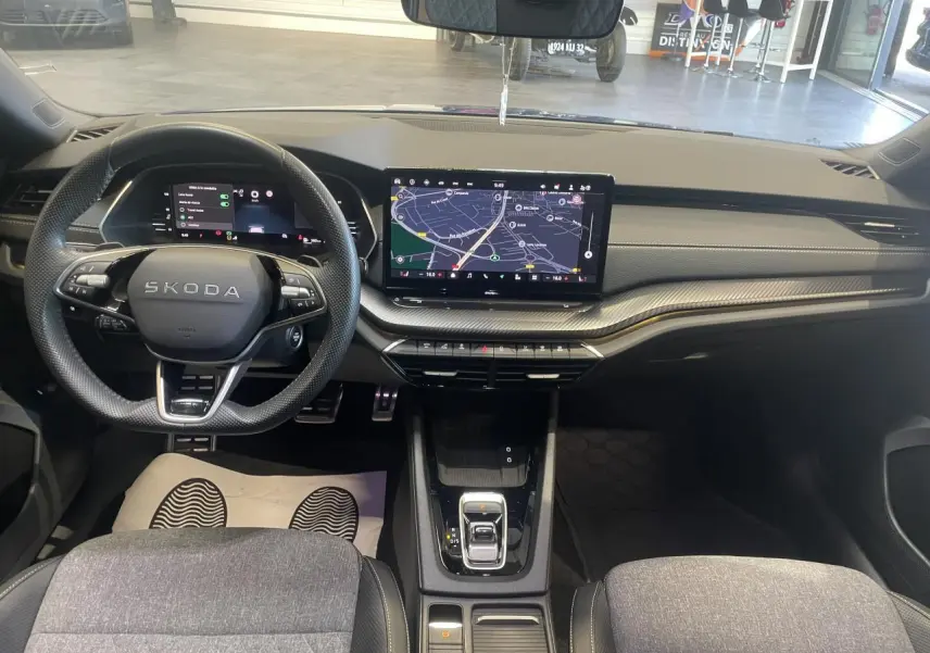 Vue intérieure avant du tableau de bord et volant Skoda Octavia 2025, finition Sportline avec écran tactile central allumé.