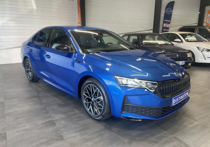 Vue 3/4 avant gauche d'une Skoda Octavia 2025 bleu foncé avec jantes alliage noires et calandre noire sportive.