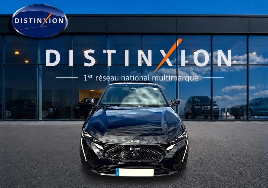 Vue frontale d'une Peugeot 308 noire 2025 garée devant une vitrine avec logo Distinxion en arrière-plan.