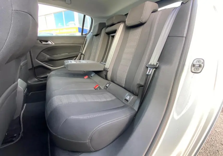 Vue intérieure côté droit des sièges arrière noirs avec accoudoir central relevé d'une Peugeot 308 gris aluminium de 2016.