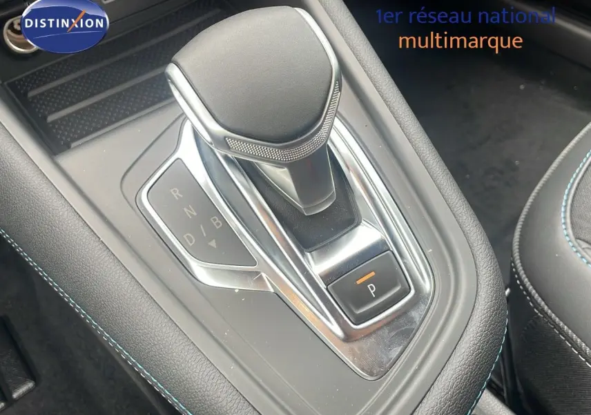 Le levier de vitesses automatique du Renault Captur E-Tech hybride 2025, avec coutures bleues sur console noire.