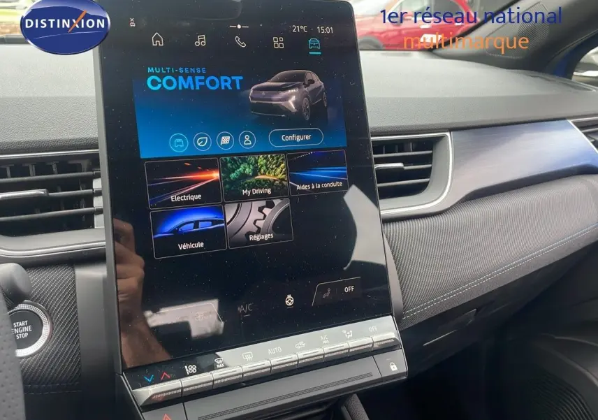 Vue rapprochée de la console centrale tactile du Renault Captur bleu Iron Metal avec finition intérieure gris et commandes climatisation.