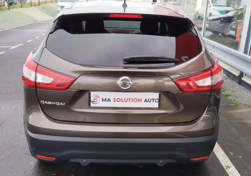 Vue arrière d'un Nissan Qashqai 2017 couleur bronze ultime avec vitres teintées et logo visible sur le hayon.