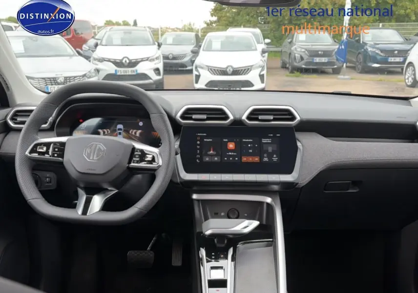 Vue intérieure avant du tableau de bord gris du MG ZS Hybrid 197 avec écran tactile et volant multifonction.