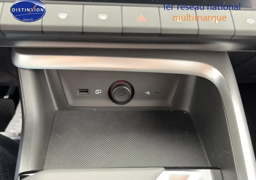 Vue rapprochée de la console centrale grise du MG ZS Hybrid 197 avec prises USB et allume-cigare 12V.