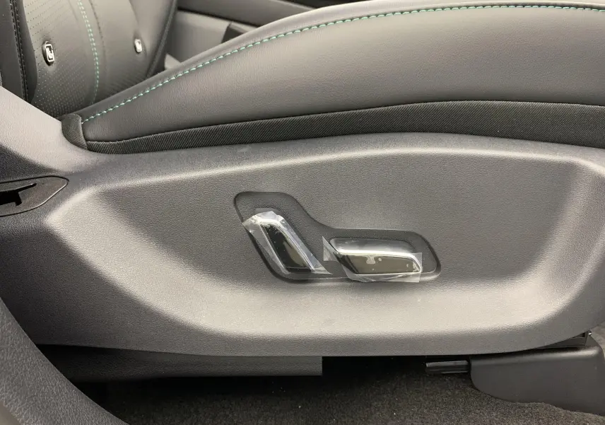 Détail des commandes de réglage électrique du siège en cuir noir avec surpiqûres vertes dans une BYD SEAL U 2026.