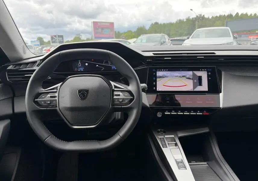 Vue intérieure centrée sur le volant Peugeot 308 gris, avec écran tactile affichant la caméra de recul.