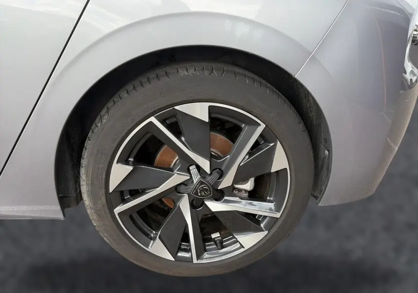 Gros plan sur la roue arrière droite de la Peugeot 308 gris artense avec jante alu noire et argentée au design moderne.