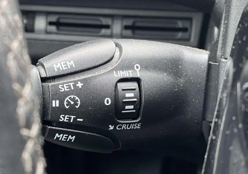 Gros plan sur la commande de régulateur de vitesse du Peugeot 3008 2017, finition Allure, intérieur noir.