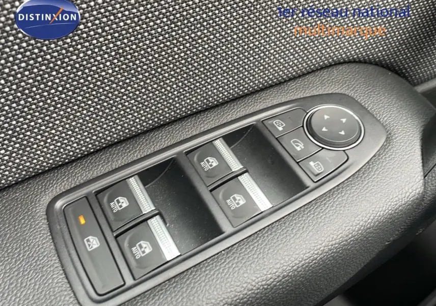 Gros plan sur les commandes de lève-vitres et rétroviseurs côté conducteur du Renault Captur gris Rafale 2025.