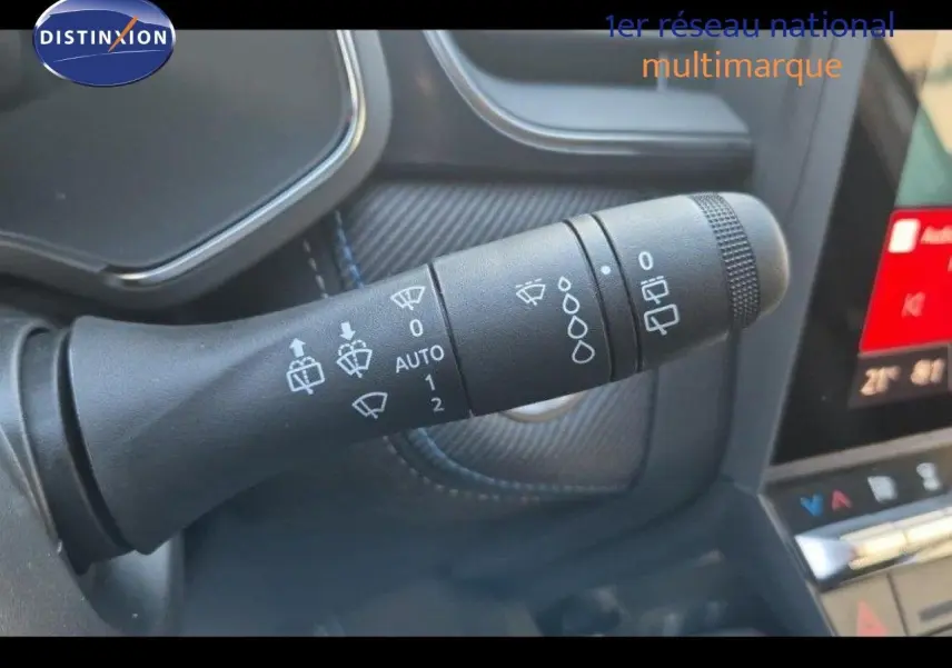 Gros plan sur la commande d’essuie-glace du Renault Captur gris Rafale, intérieur avec détails de la console tactile.